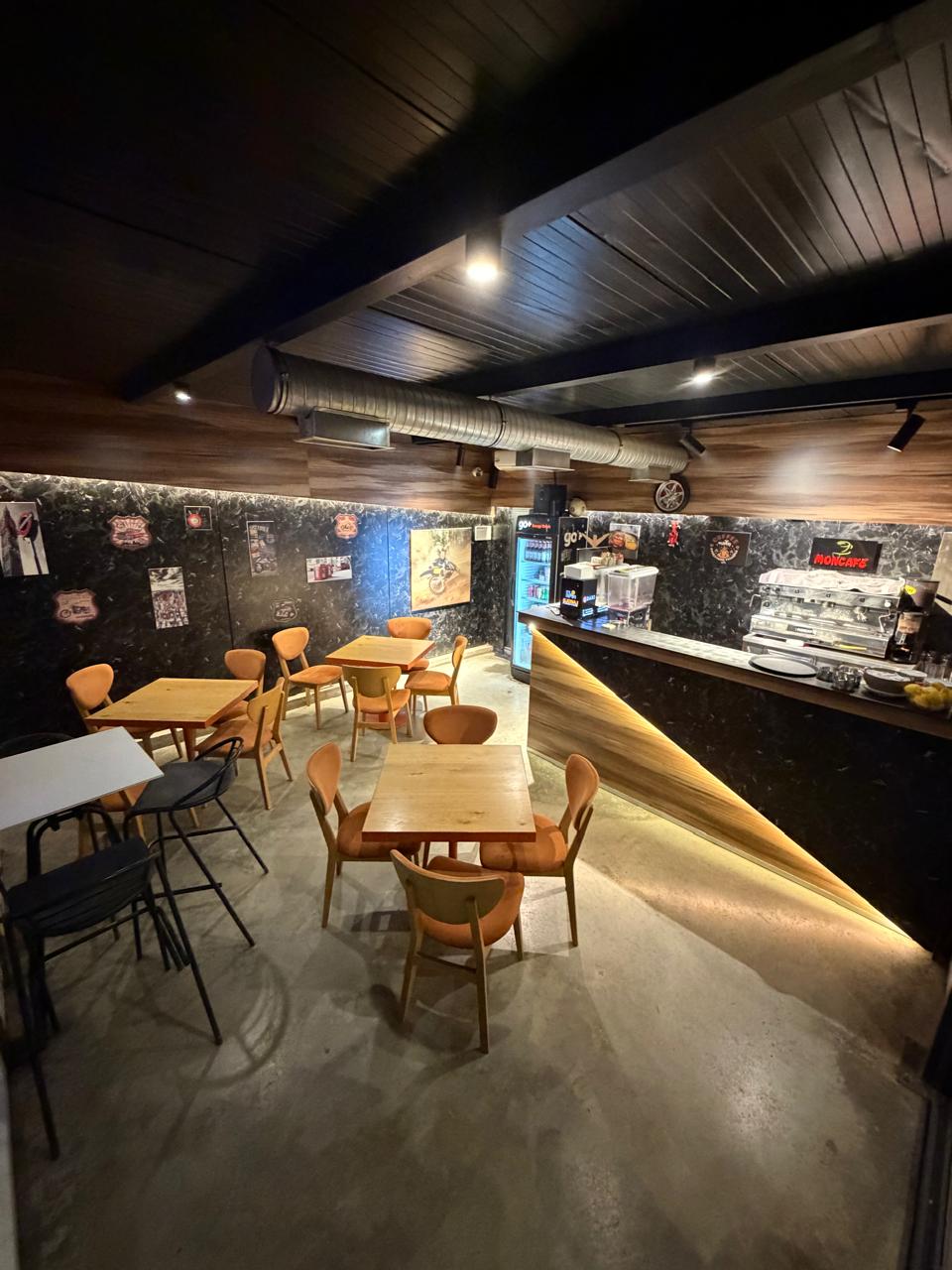 Pitstop Cafe interior - warm industrial atmosphere with wooden tables and bar counter